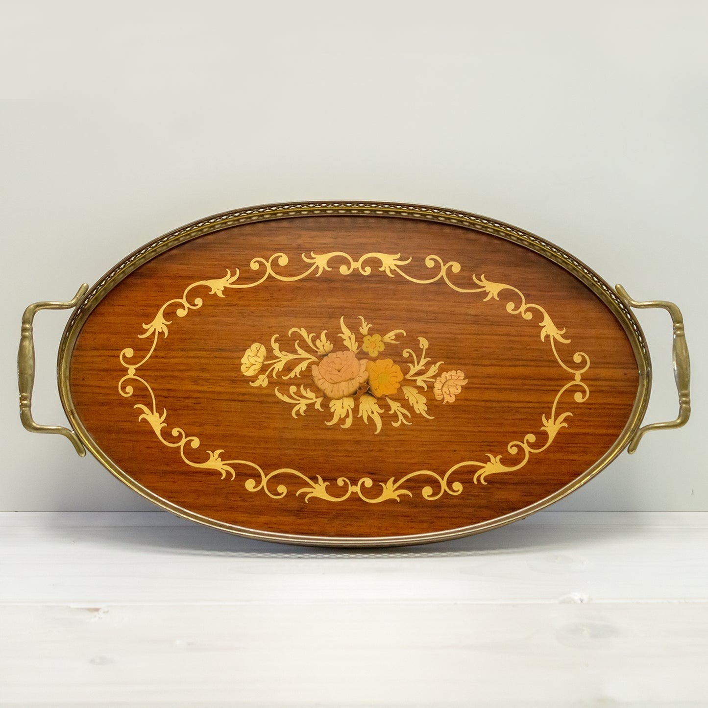 Oval tray made of olive wood with brass border and handles