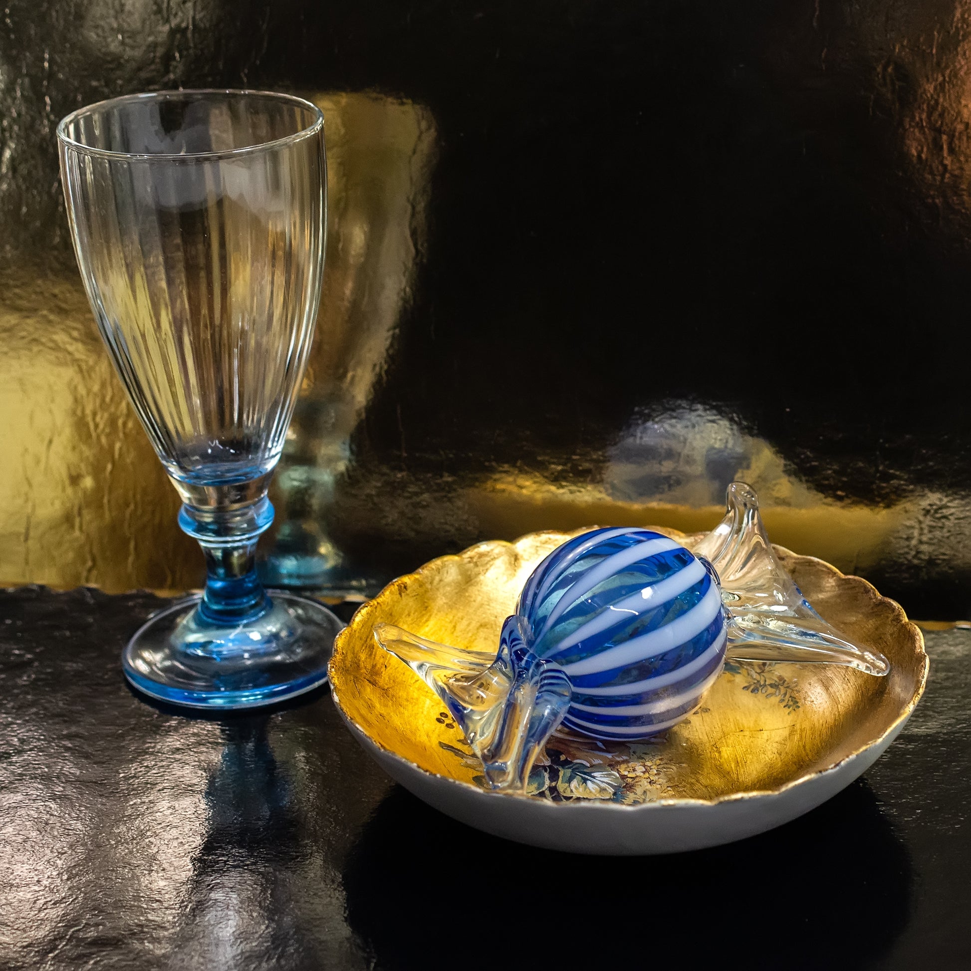 Blue Murano glass candy on golden plate