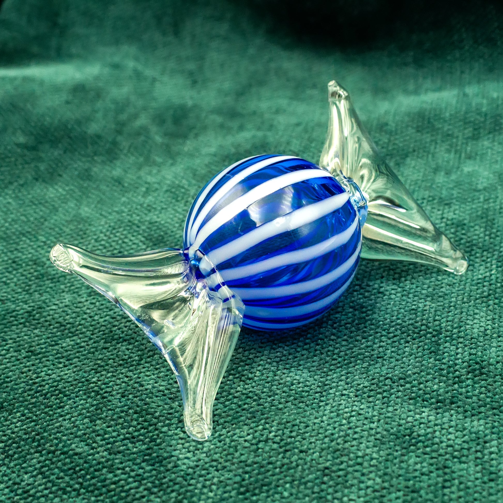 Blue-white Murano glass candy on green background